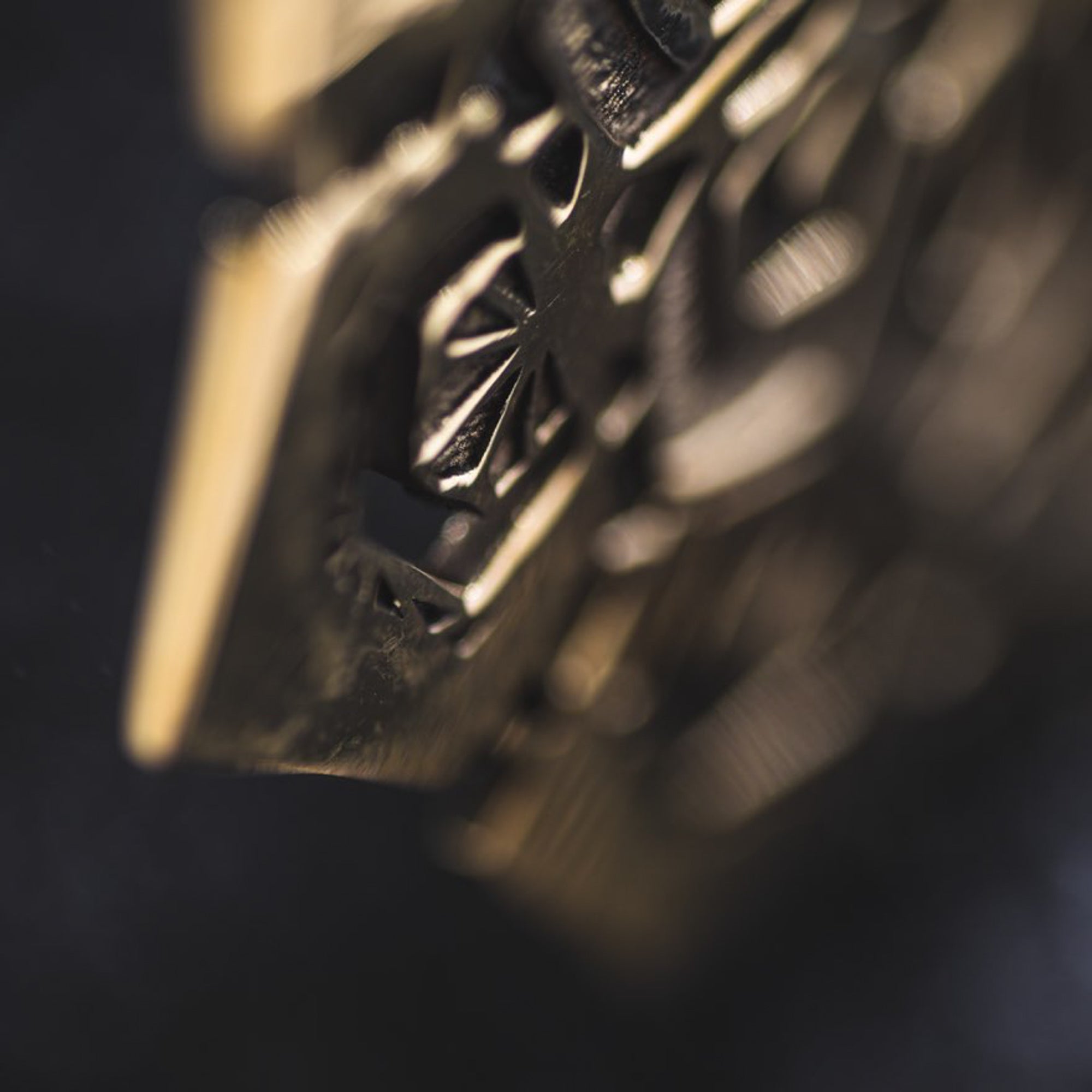 Close-up image of Kaya Movement's ASA Oversized Asa No Ha Mandala Disc Earrings in Gold, showcasing intricate and ornate patterns that feature geometric shapes and a starburst design reminiscent of the traditional Asanoha motif. The worn edges suggest age, while the dark background enhances the detailed carvings of these ethnic statement earrings.